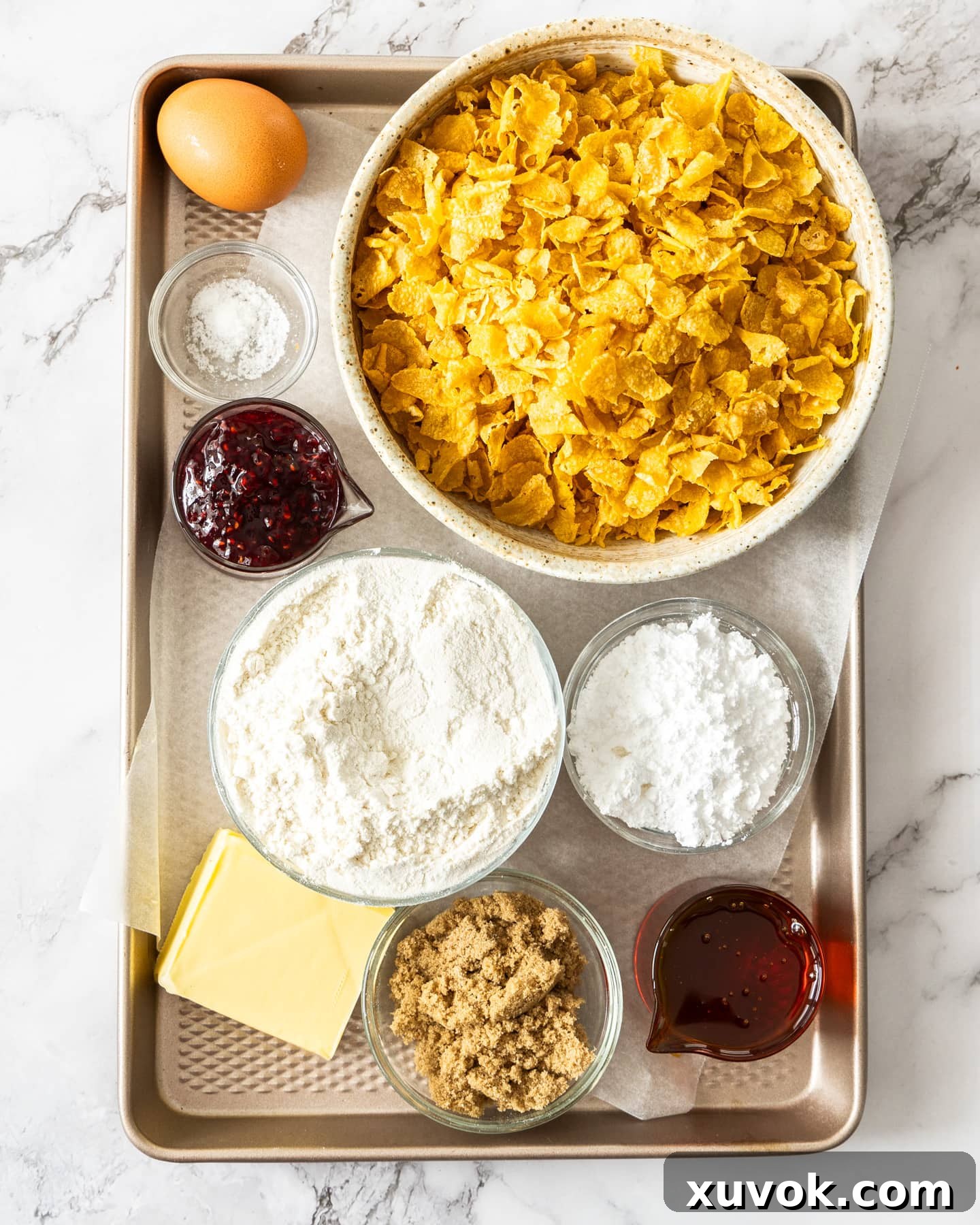 A flat lay of all the essential ingredients for making a classic Cornflake Tart, neatly arranged on a baking tray, ready for preparation.