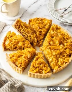 A perfectly baked Cornflake Tart with several slices removed, revealing its delicious layers, ready to be served.