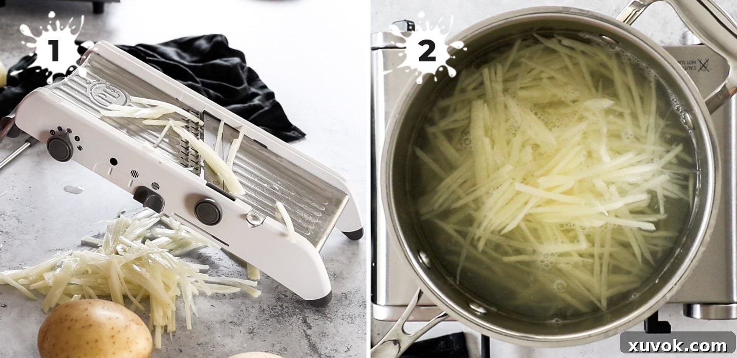 A close-up view of freshly cut, uniform shoestring potatoes, ready for blanching in a pot of hot water.