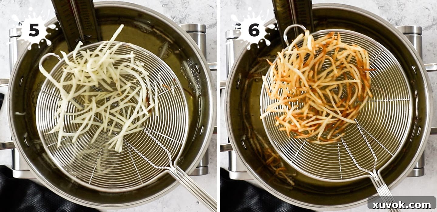 A close-up of a wire skimmer lifting perfectly golden, crispy shoestring fries out of a pot of hot oil.