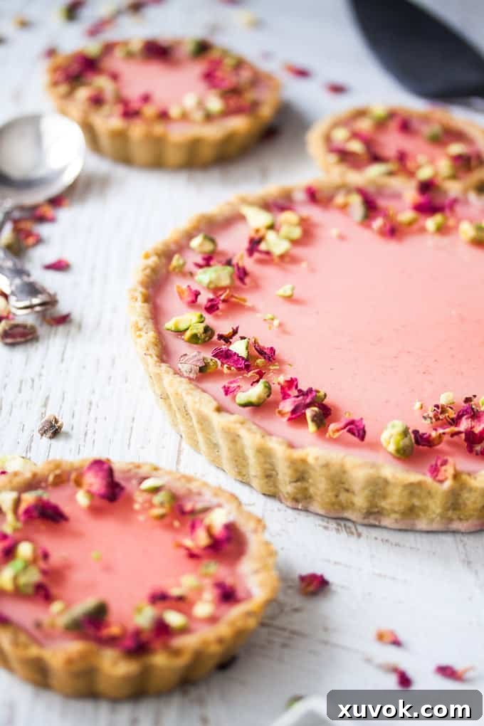 Exquisite Pistachio Rose Panna Cotta Tart, featuring a golden pistachio crust, creamy rose panna cotta, and a vibrant rose jelly topping – a perfect dessert for special gatherings.