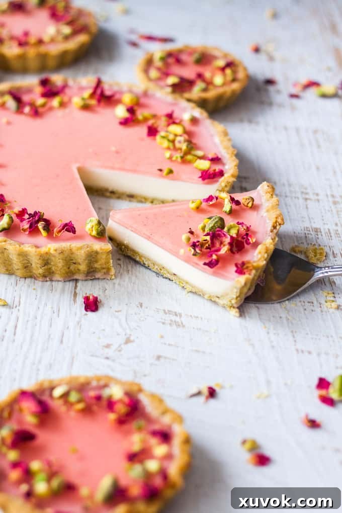 Beautifully presented Pistachio Rose Panna Cotta Tart, garnished with fresh pistachios and rose petals.
