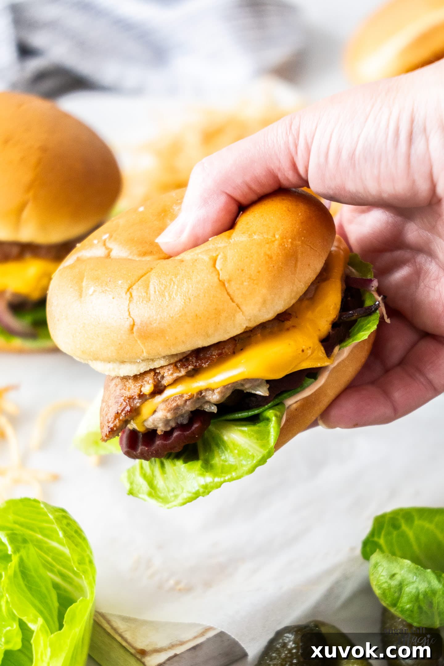 A hand holding a burger.