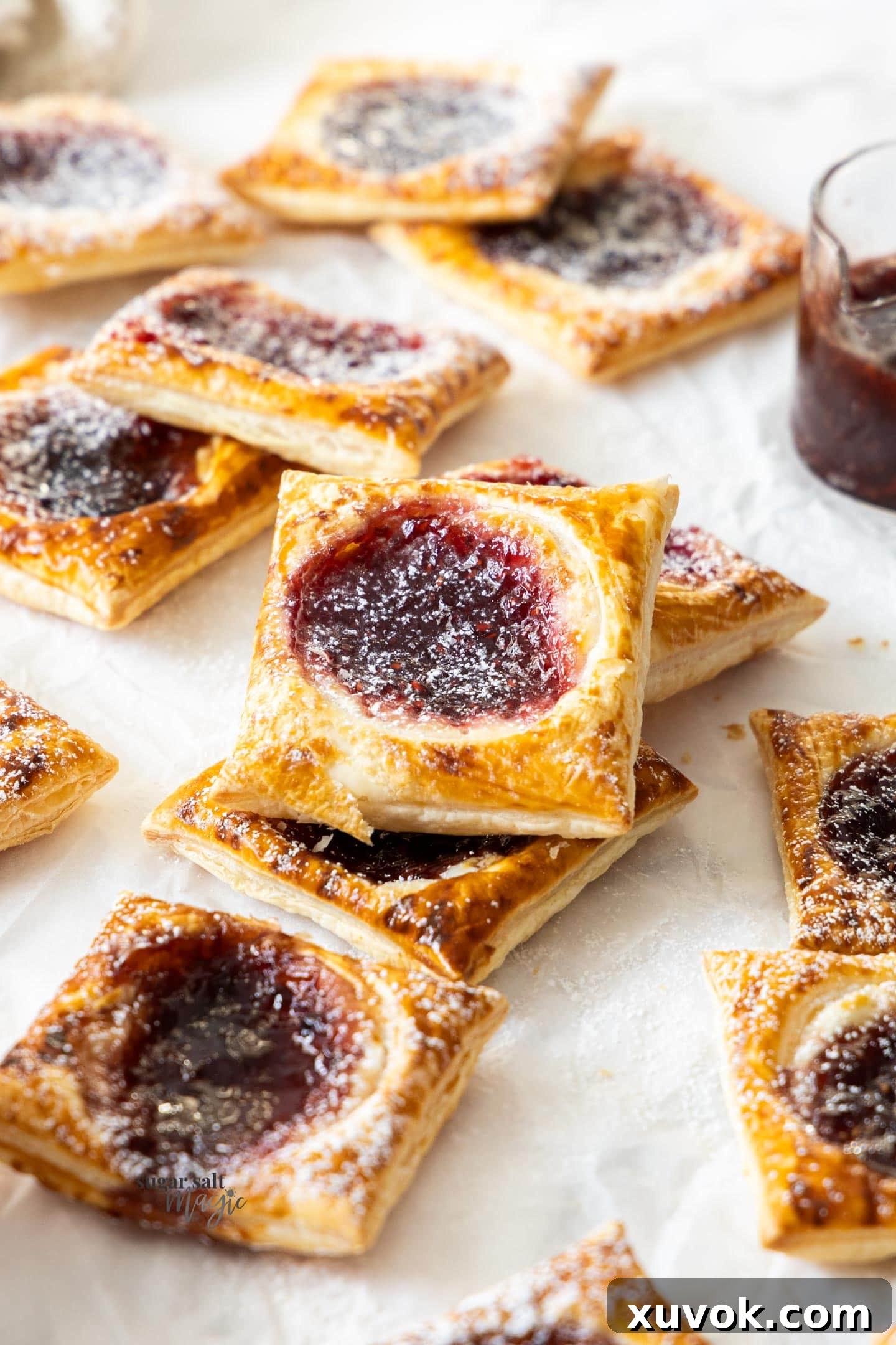 A fresh batch of puff pastry jam tarts arranged neatly on a baking sheet, golden and inviting.