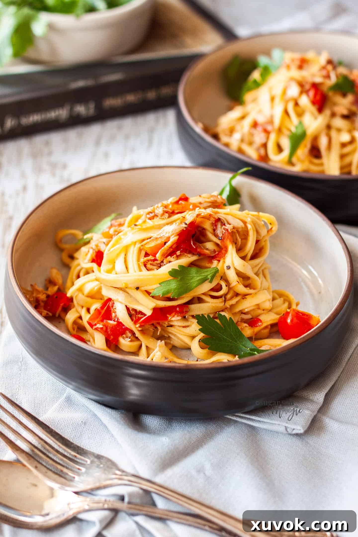two bowls filled with crab pasta with grey napkins