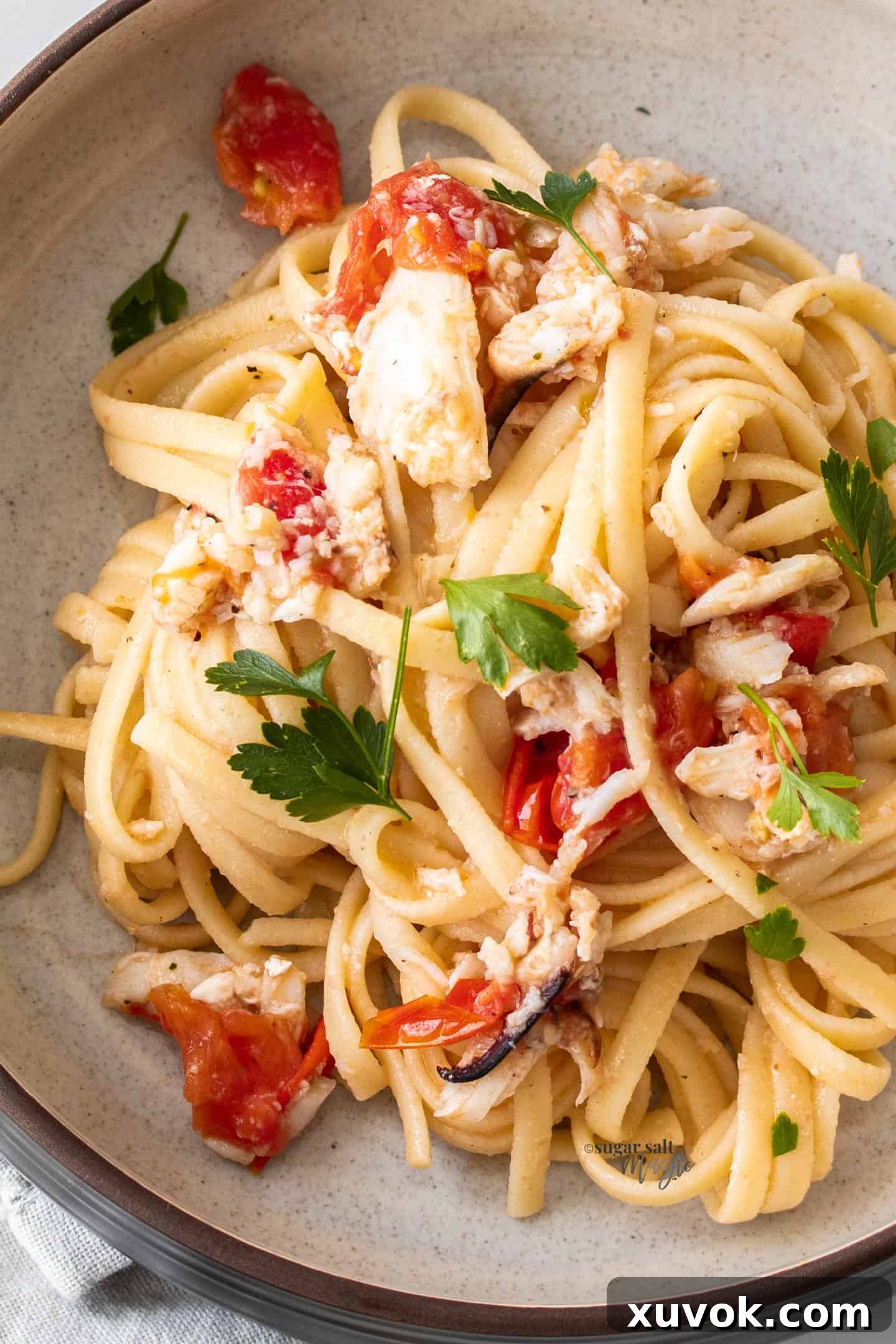 overhead closeup: tomato and crab linguine recipe in a bowl