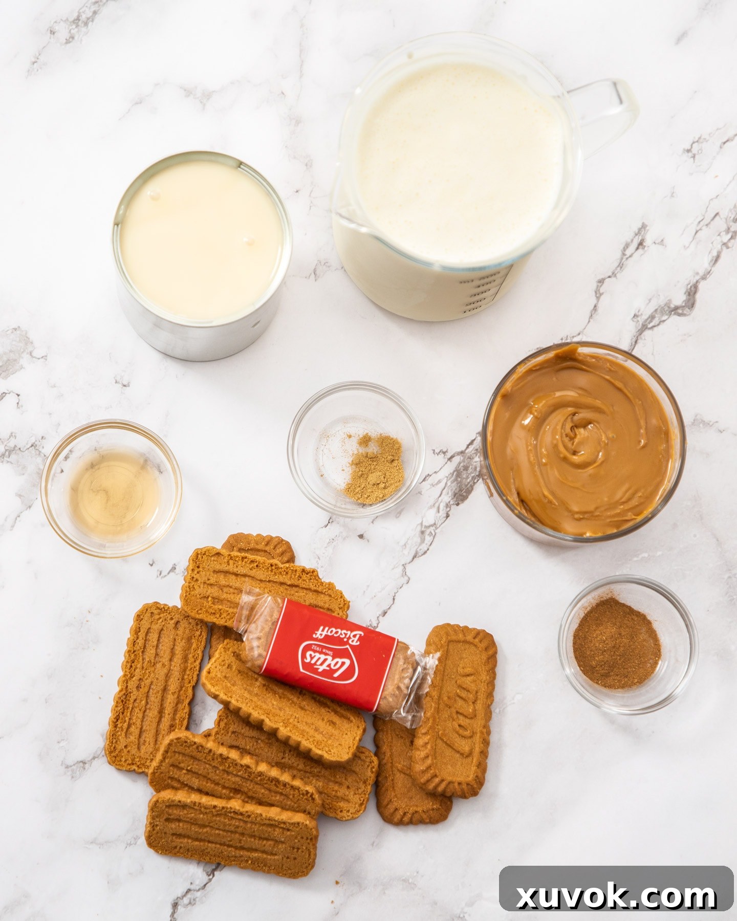 Ingredients for cookie butter ice cream laid out on a marble surface.