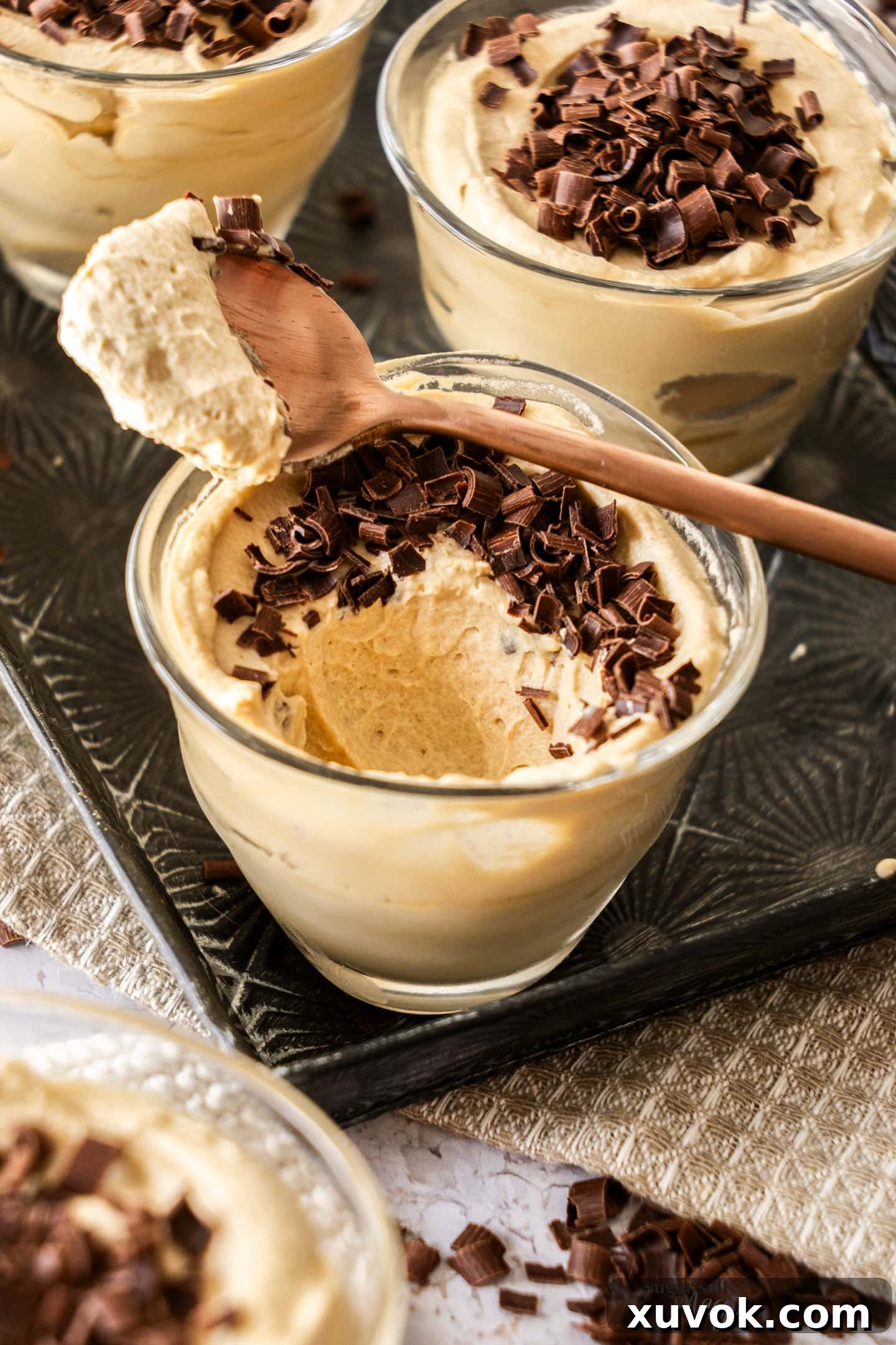A perfectly set coffee mousse, presented in a glass with a spoonful delicately taken, revealing its creamy and airy texture.