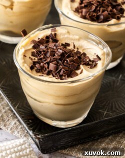 Closeup of a perfectly crafted coffee mousse topped with delicate chocolate shavings, highlighting its rich texture and appealing garnish.
