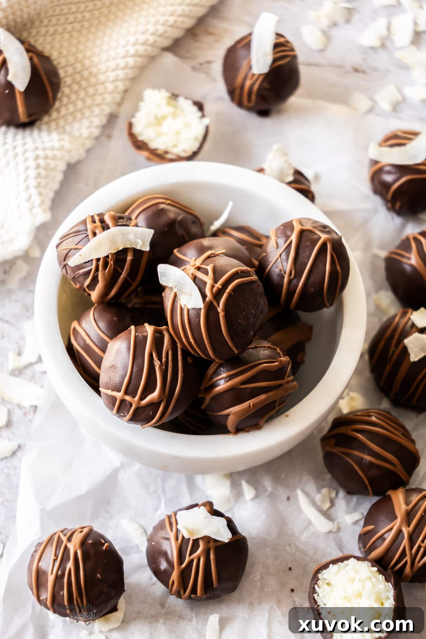 A vibrant pile of chocolate covered coconut truffles arranged elegantly in a marble bowl.