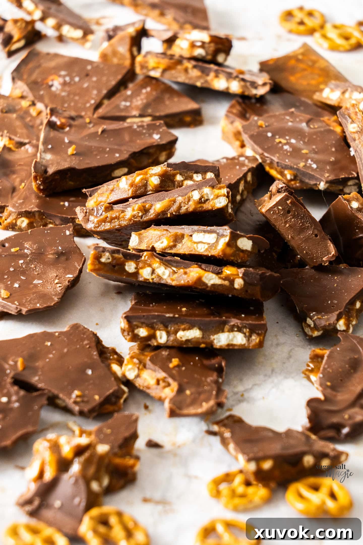 A batch of butter toffee broken up into pieces, featuring pretzels and chocolate.