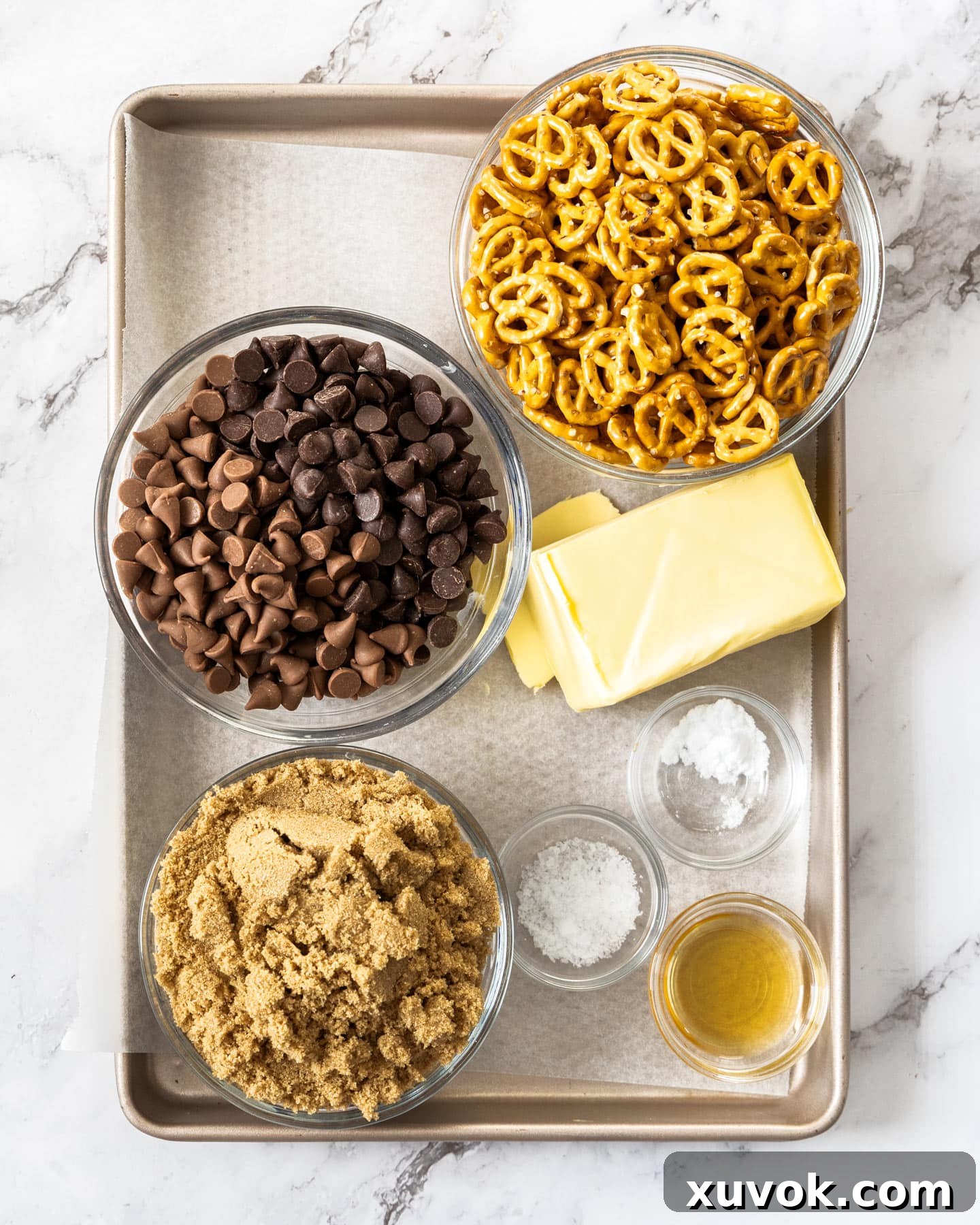Ingredients for pretzel Christmas crack on a baking tray, ready for preparation.