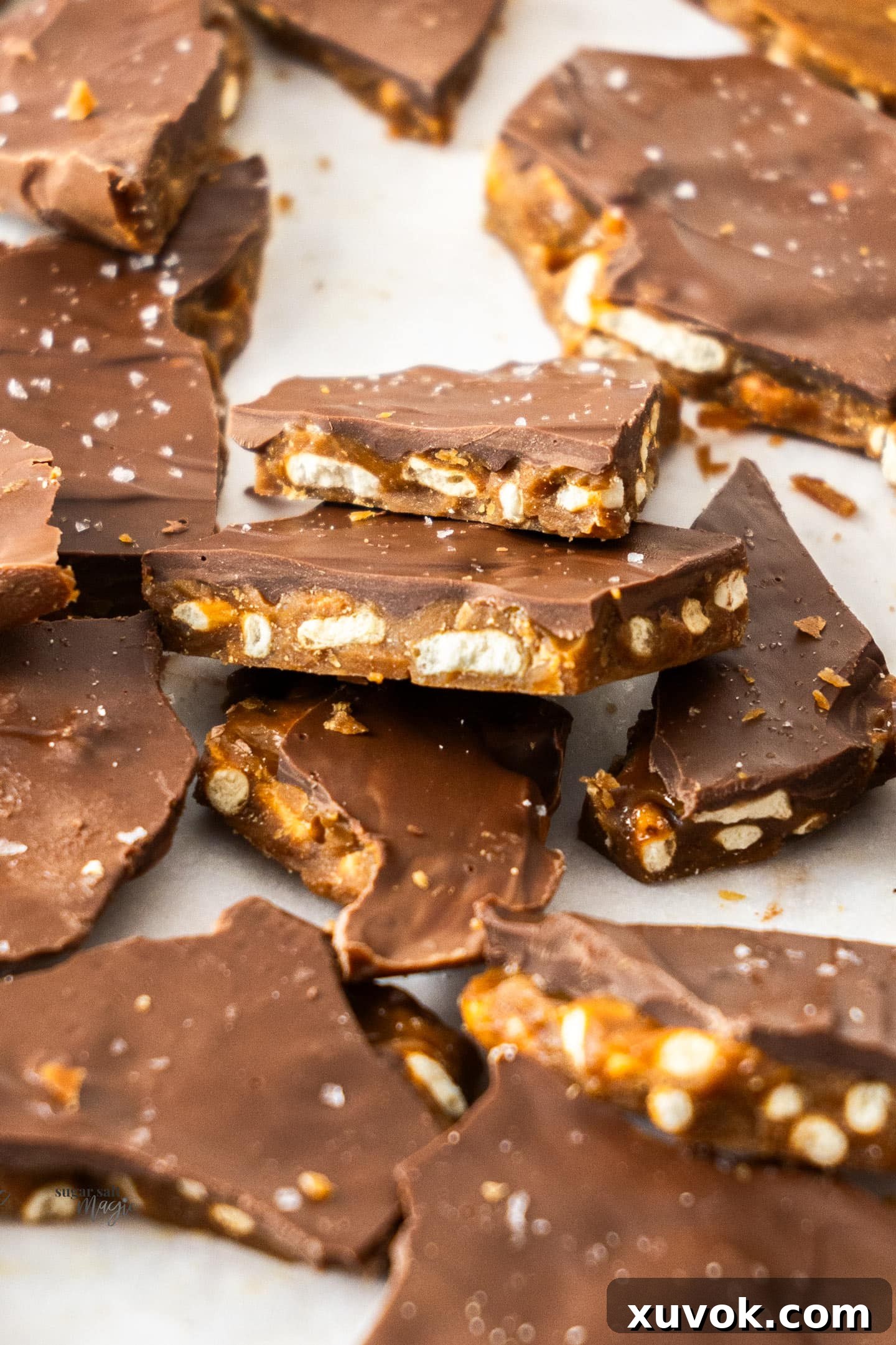 Pieces of christmas crack angled to the camera to show the beautiful layers of toffee, pretzels, and chocolate.