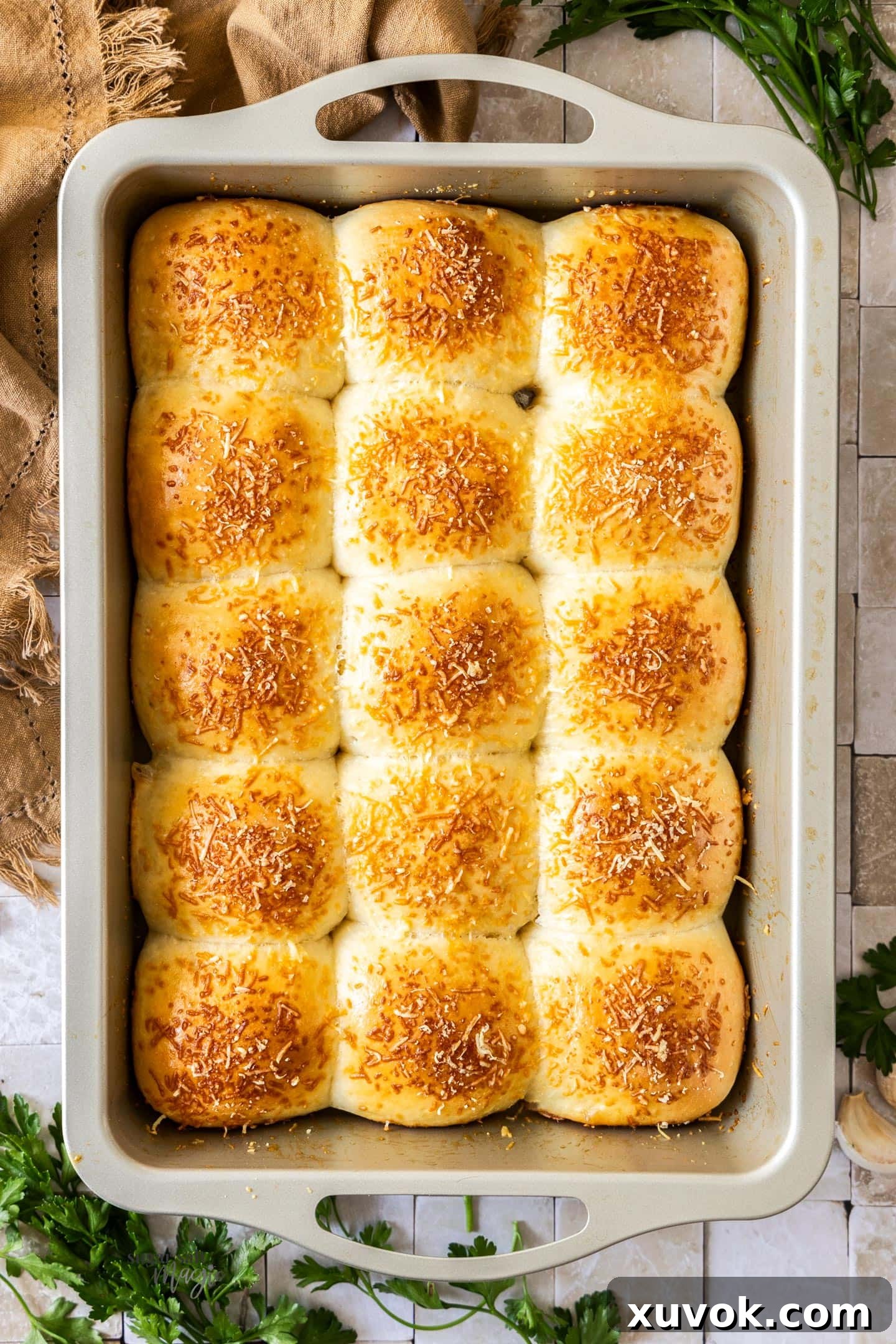 A top-down shot of golden-brown garlic dinner rolls fresh out of the oven, before being brushed with butter.