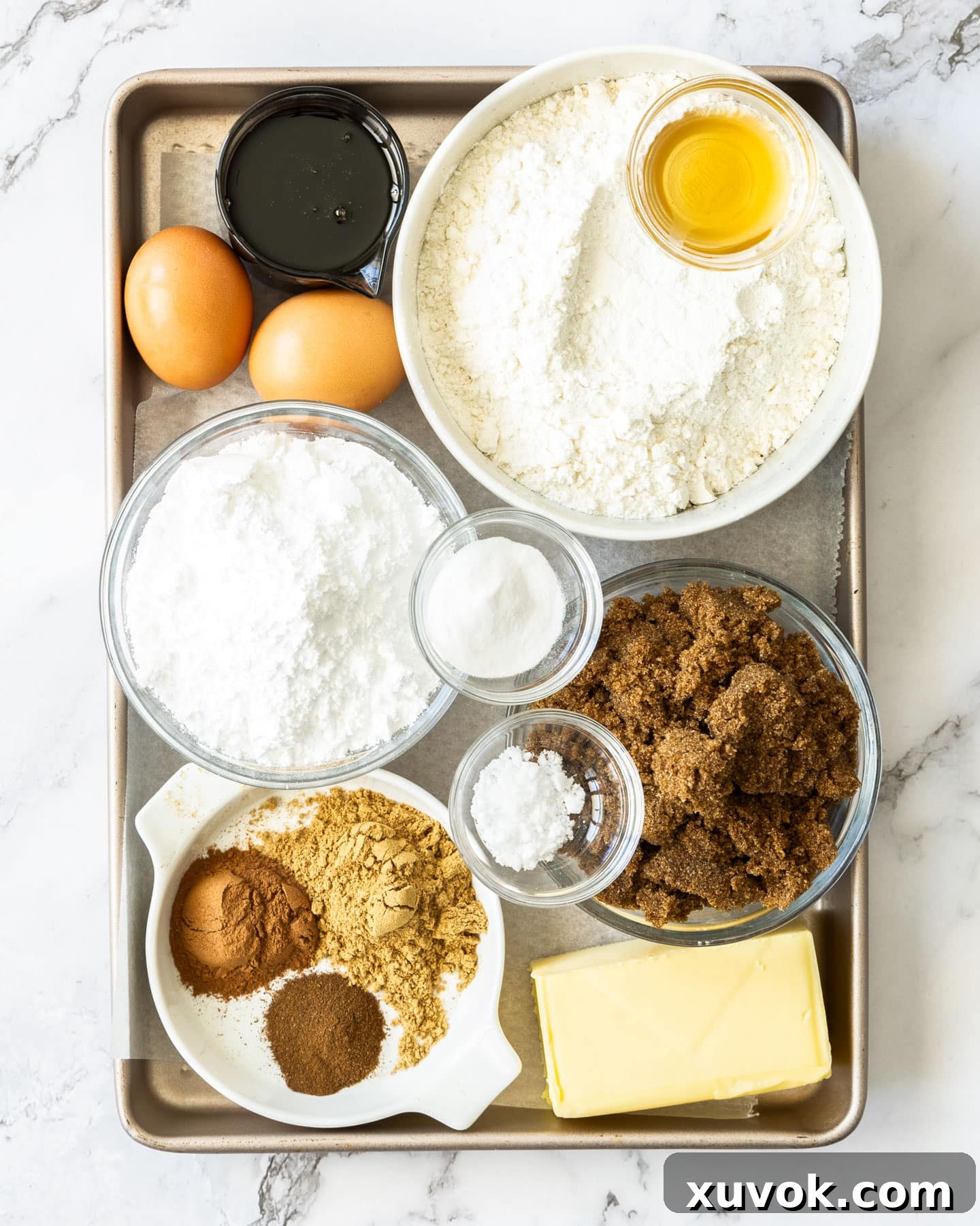 A carefully arranged collection of ingredients for gingerbread crinkle cookies, including spices, flour, molasses, and sugar, on a rustic surface.