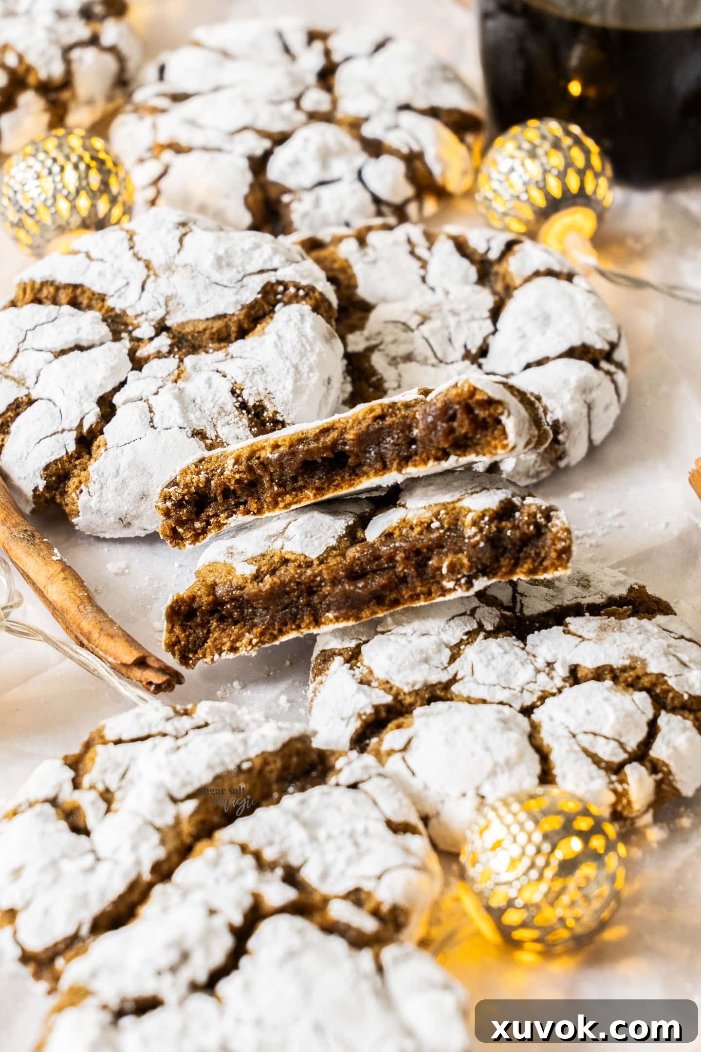 A beautifully broken gingerbread crinkle cookie showing its soft, chewy interior texture and the distinct spice specks, emphasizing its deliciousness.