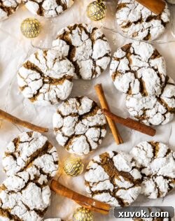 A top-down view of beautifully arranged gingerbread crinkle cookies, softly illuminated by festive Christmas lights in the background.