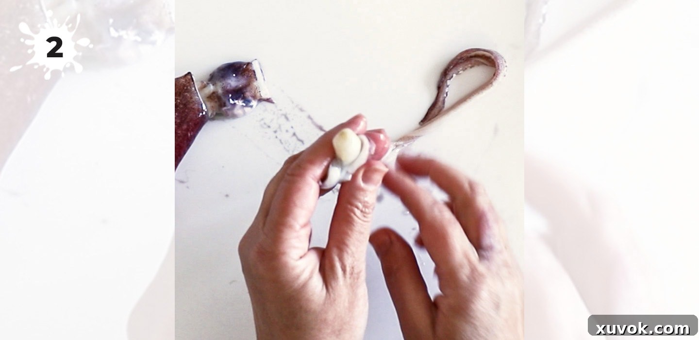 Removing the inedible beak from the center of the squid's tentacles.