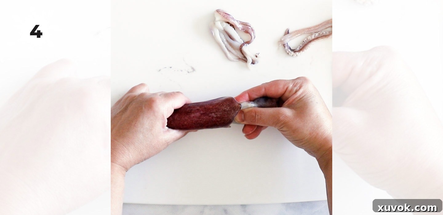 Pulling the internal organs and head section out from the squid mantle.