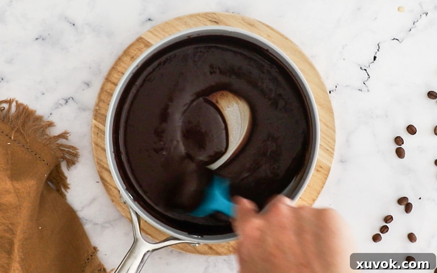 Stirring the melted chocolate and cream to a ganache.