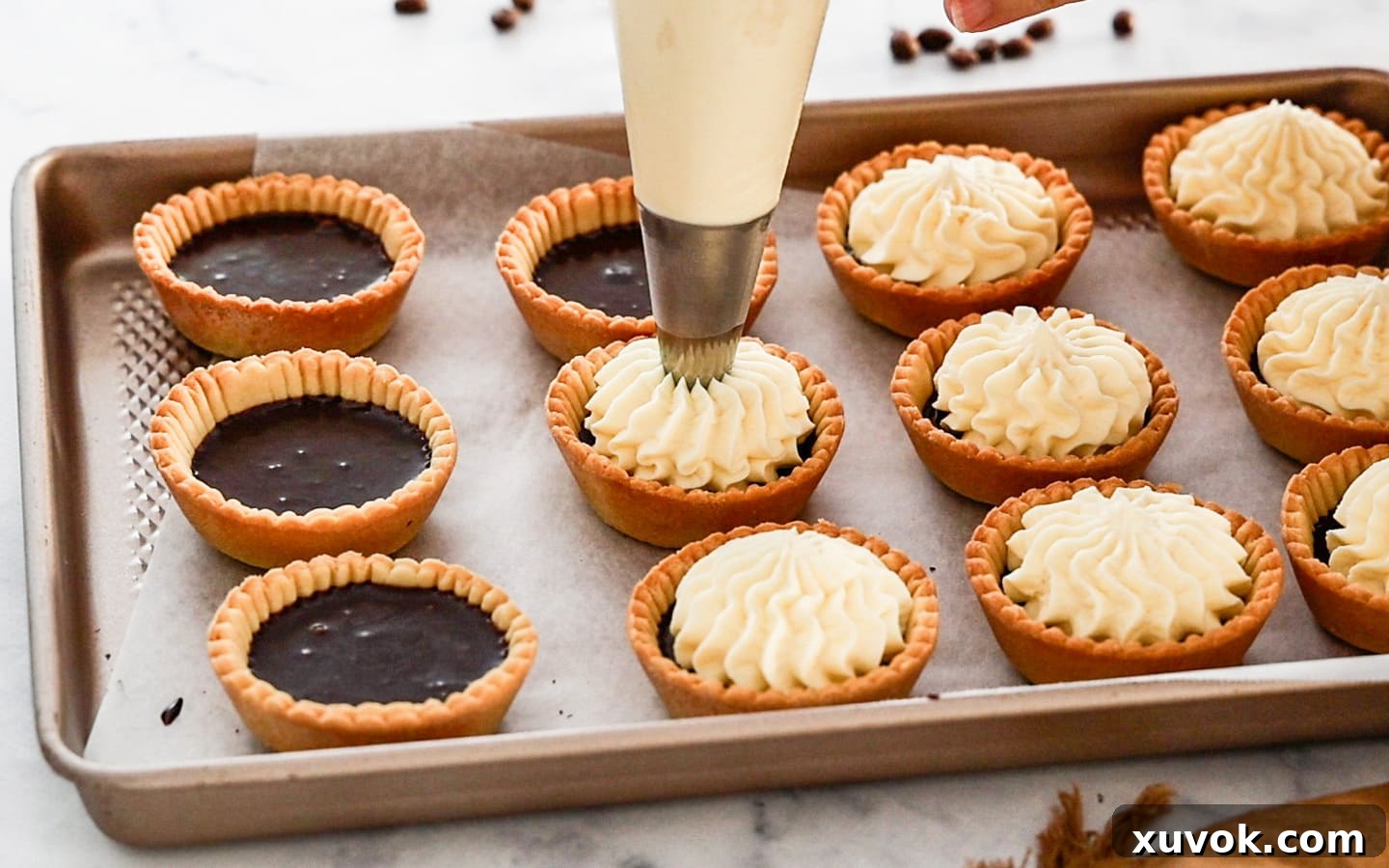 Piping cream onto the tartlets.