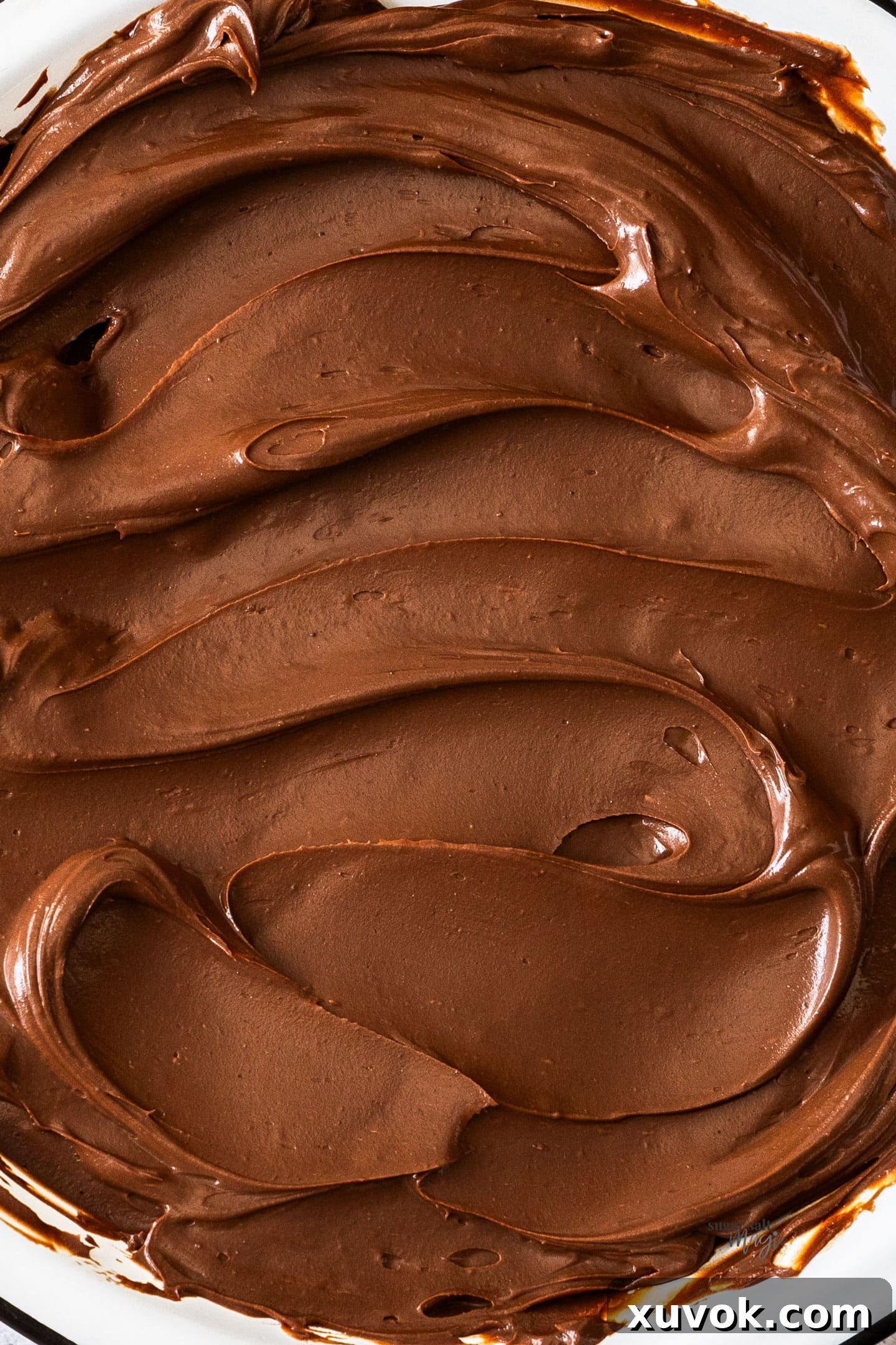 Closeup of chocolate cremeux swirls, highlighting its smooth and luxurious texture.