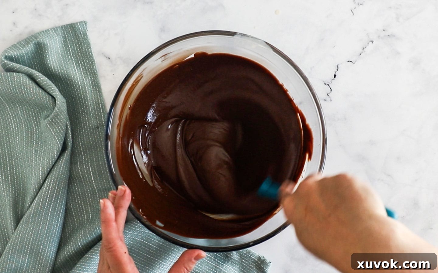 Stirring the chocolate into the creme anglaise, showing the creamy, smooth emulsion forming.
