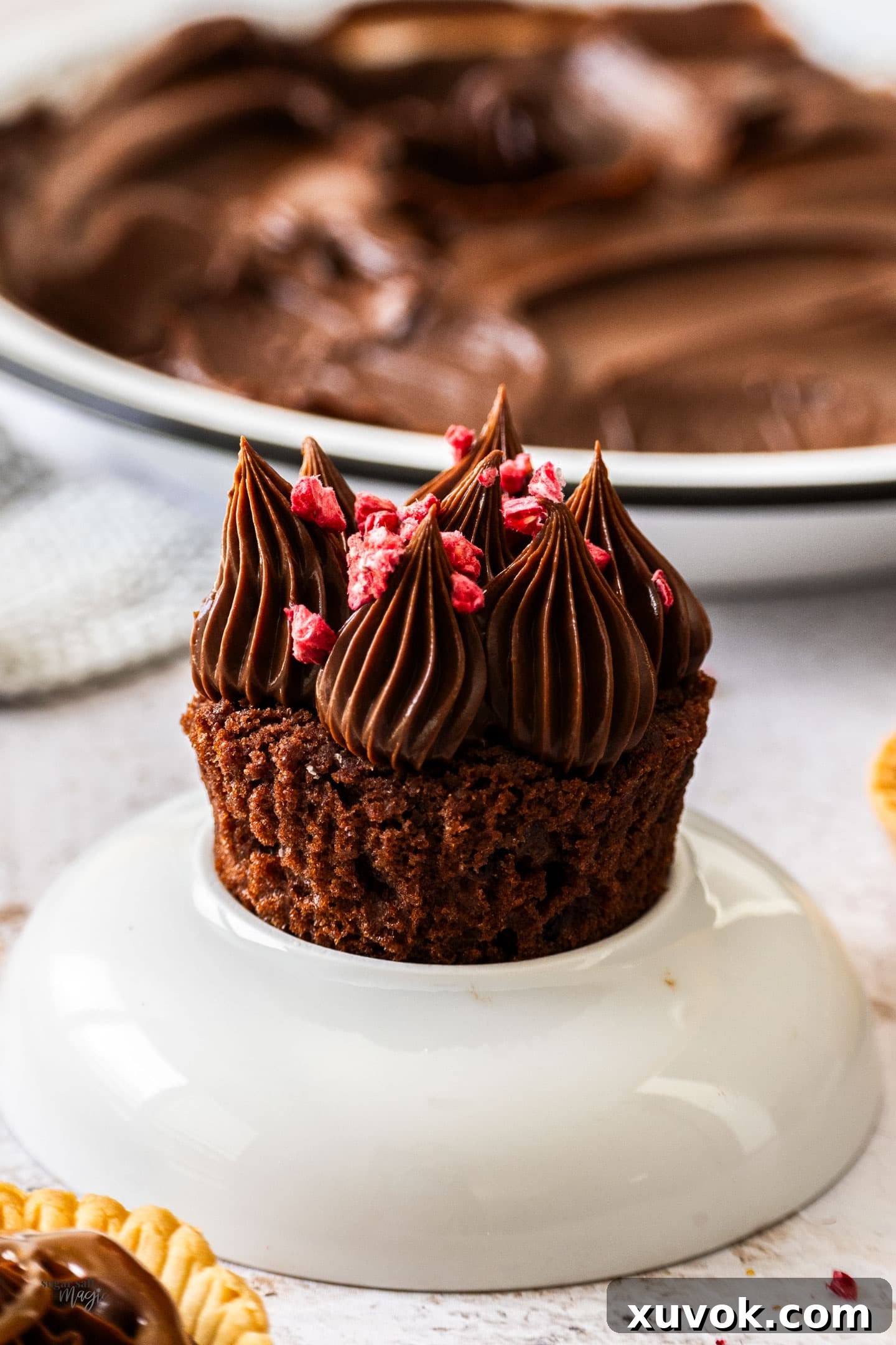 Piped stars of chocolate cremeux adorning a mini cake, showcasing its pipeable and stable texture.