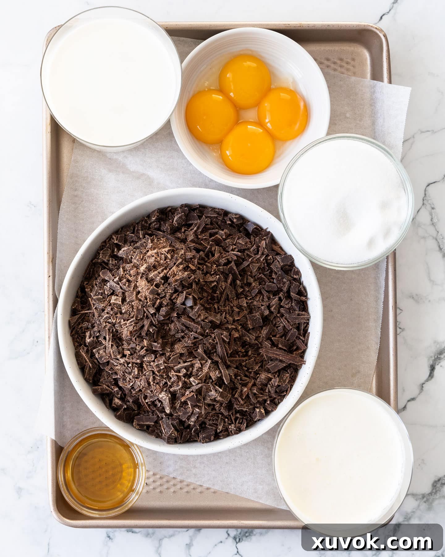 Ingredients for chocolate cremeux meticulously arranged on a baking tray, showcasing quality components.