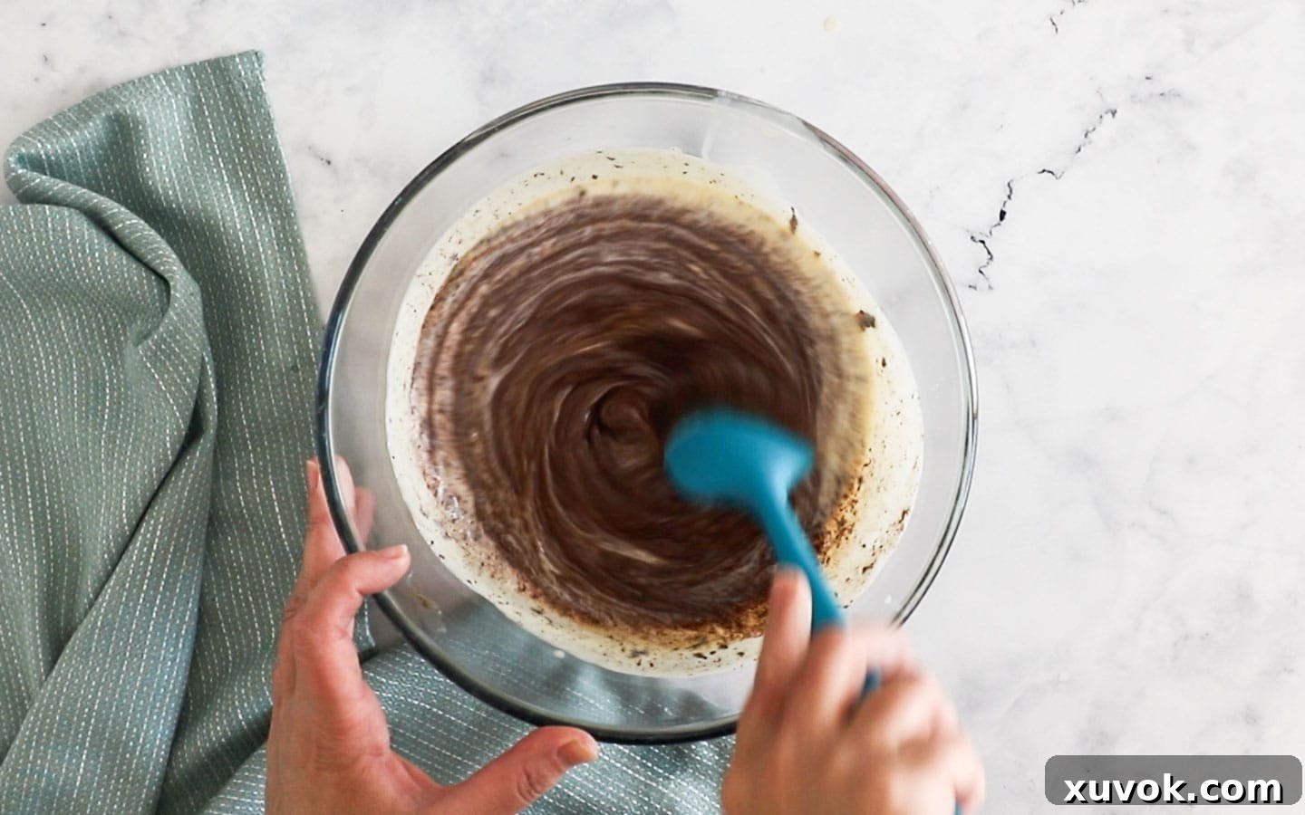 Stirring the chocolate into the creme anglaise, showing the initial blending process for the cremeux.