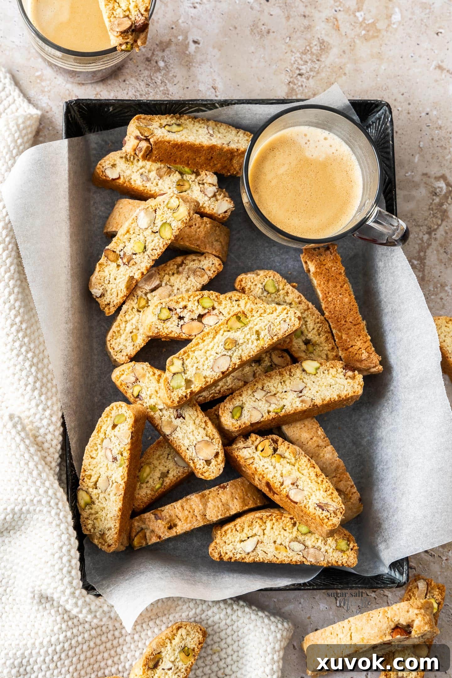 A tray filled with biscotti and a glass of coffee.