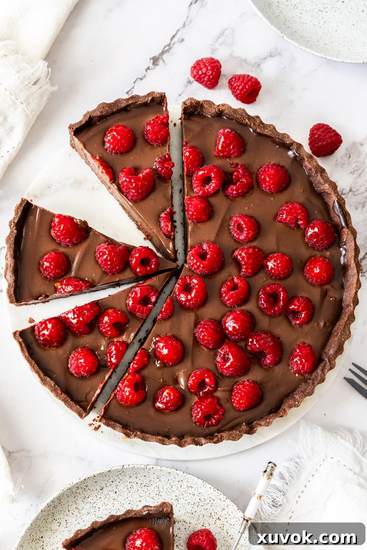 Top down view of a choc raspberry tart cut into slices.