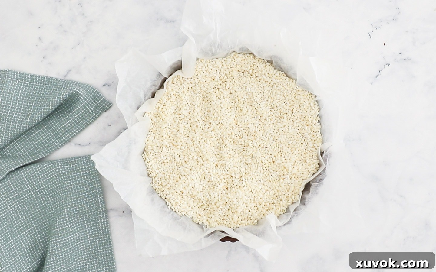The tart shell filled with baking paper and rice to weigh it down.
