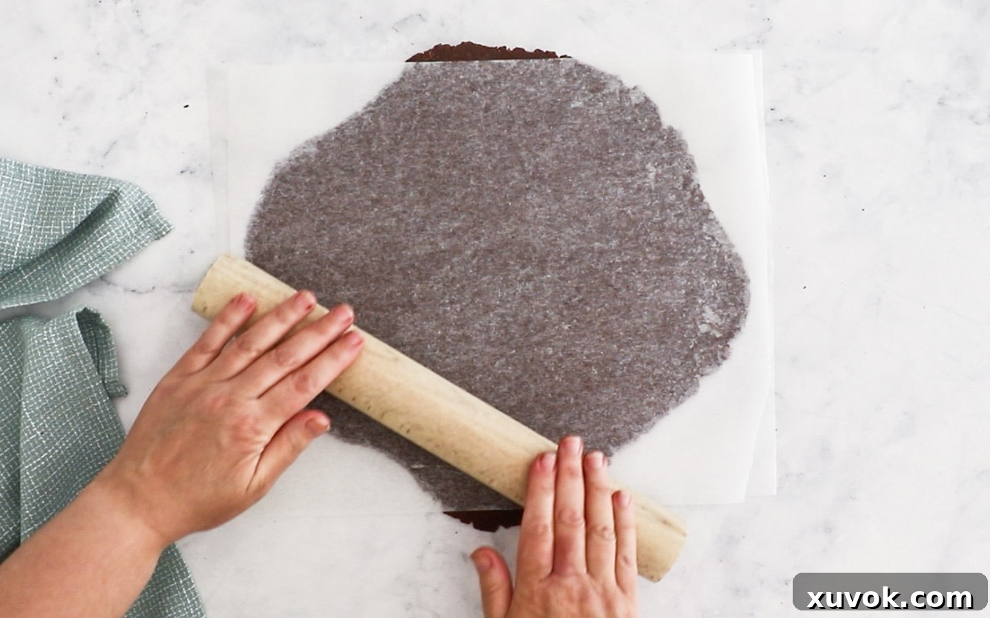 Rolling out the pastry dough between 2 sheets of baking paper.