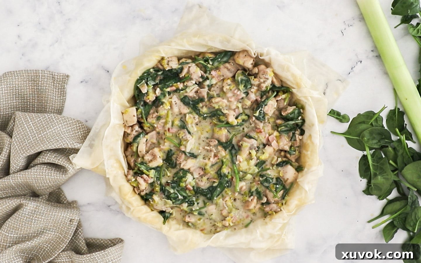 The cooled chicken and leek filling has been added to the filo pastry-lined pie dish.