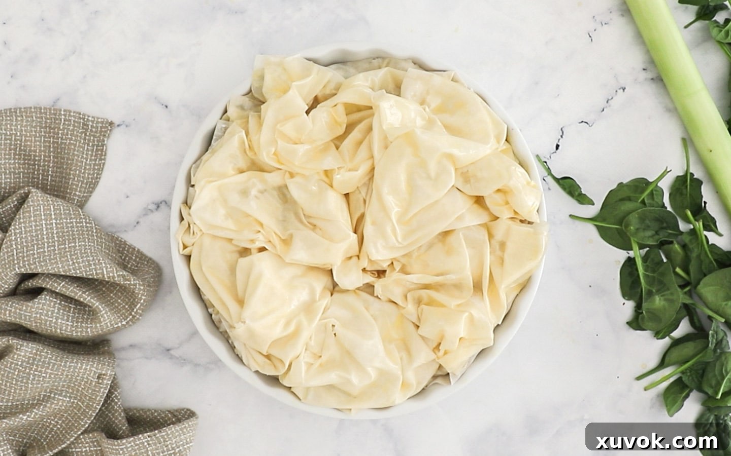 The scrunched-up, buttered filo pastry sheets artfully arranged on top of the pie, ready for baking.