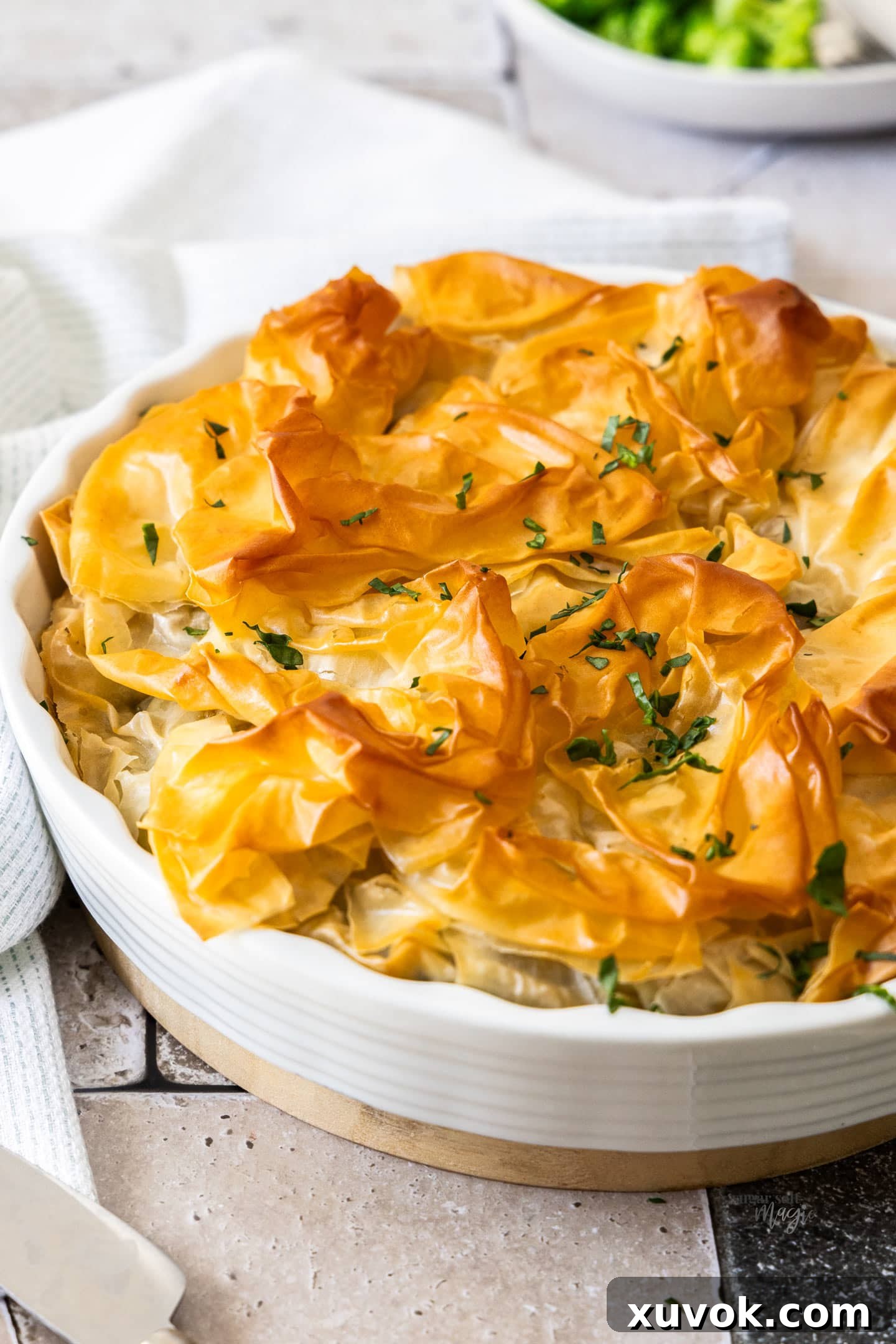 A close-up shot of the golden, crinkly, and perfectly crisp filo pastry top of the chicken pie.