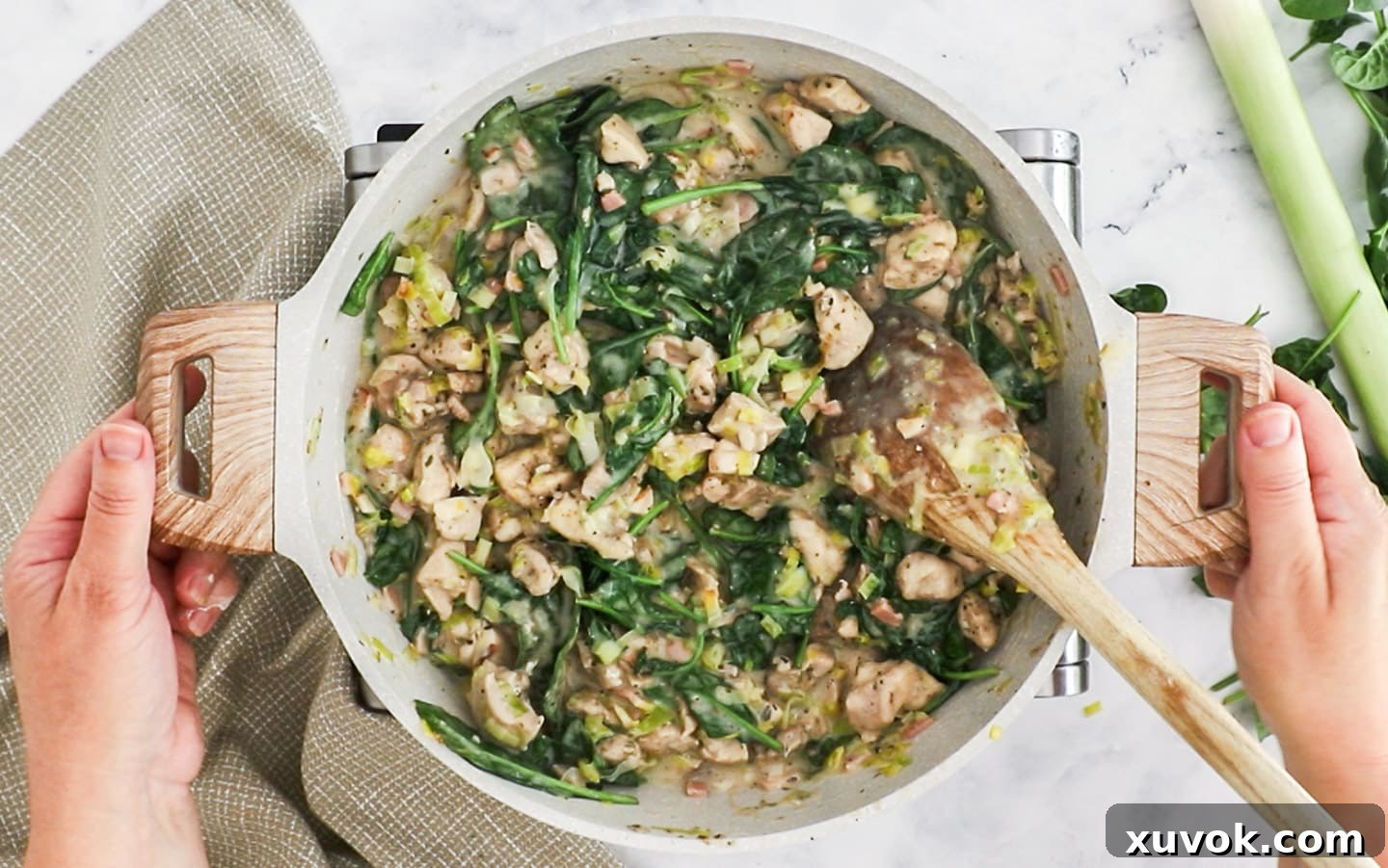 The finished chicken pie filling, thick and creamy with wilted spinach, ready to be added to the pie crust.