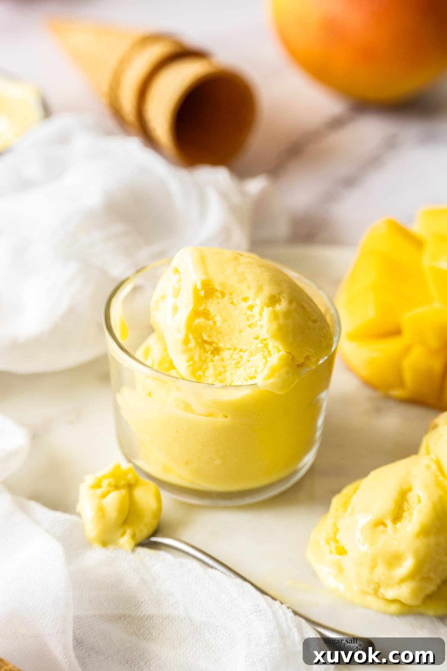A small glass bowl filled with creamy mango gelato, ready to be enjoyed.
