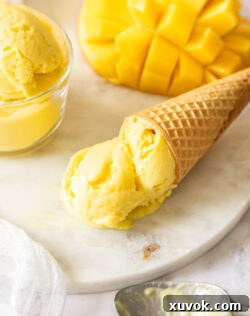 A waffle cone filled with mango gelato.