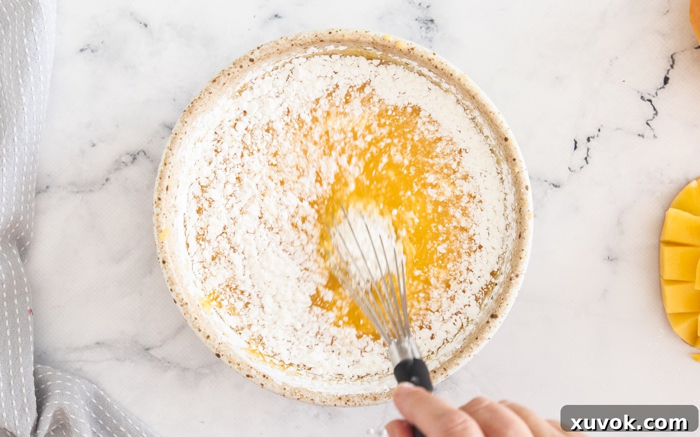 Mixing together cornflour and mango puree in a bowl.