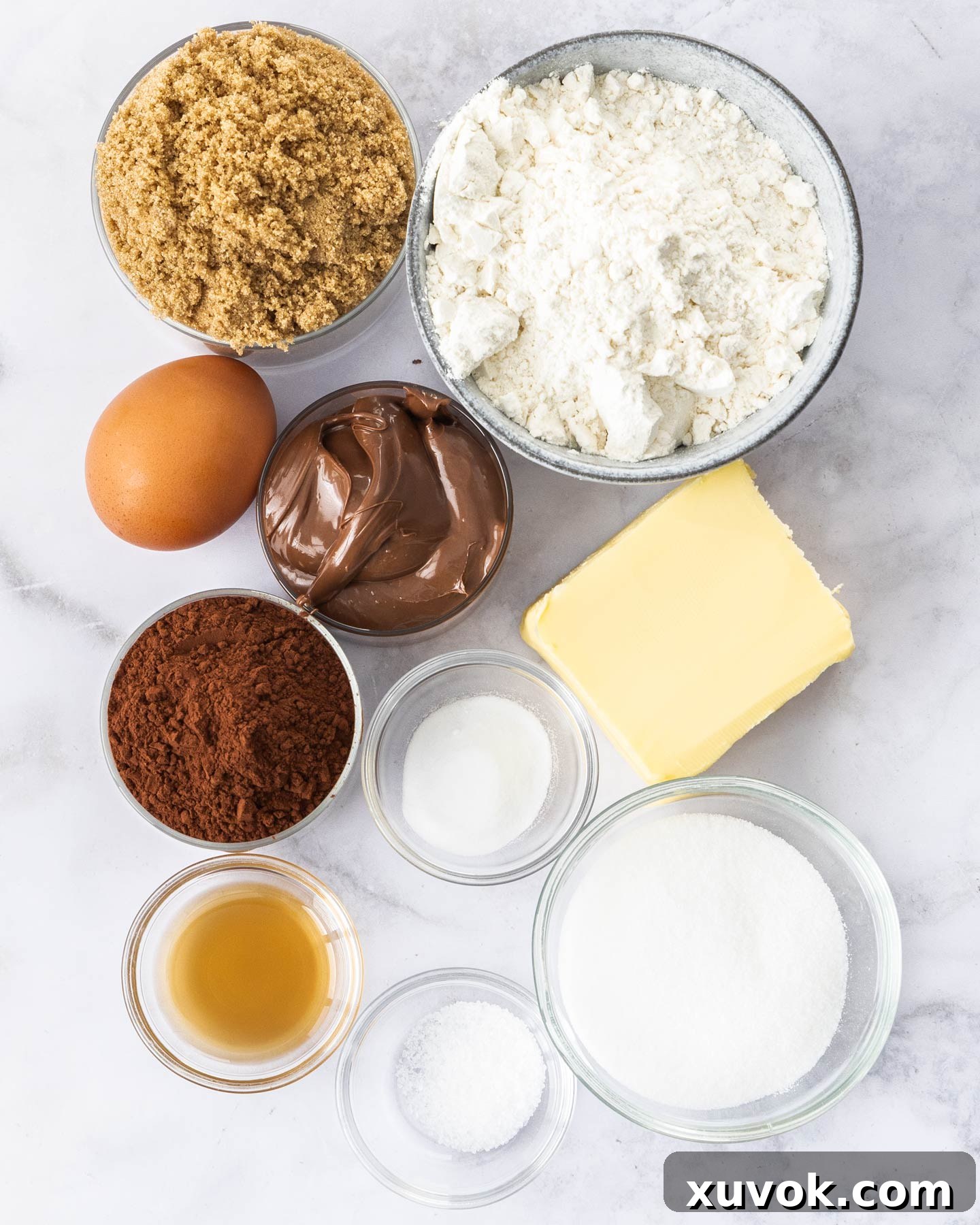 Ingredients for chocolate nutella cookies on a marble surface.