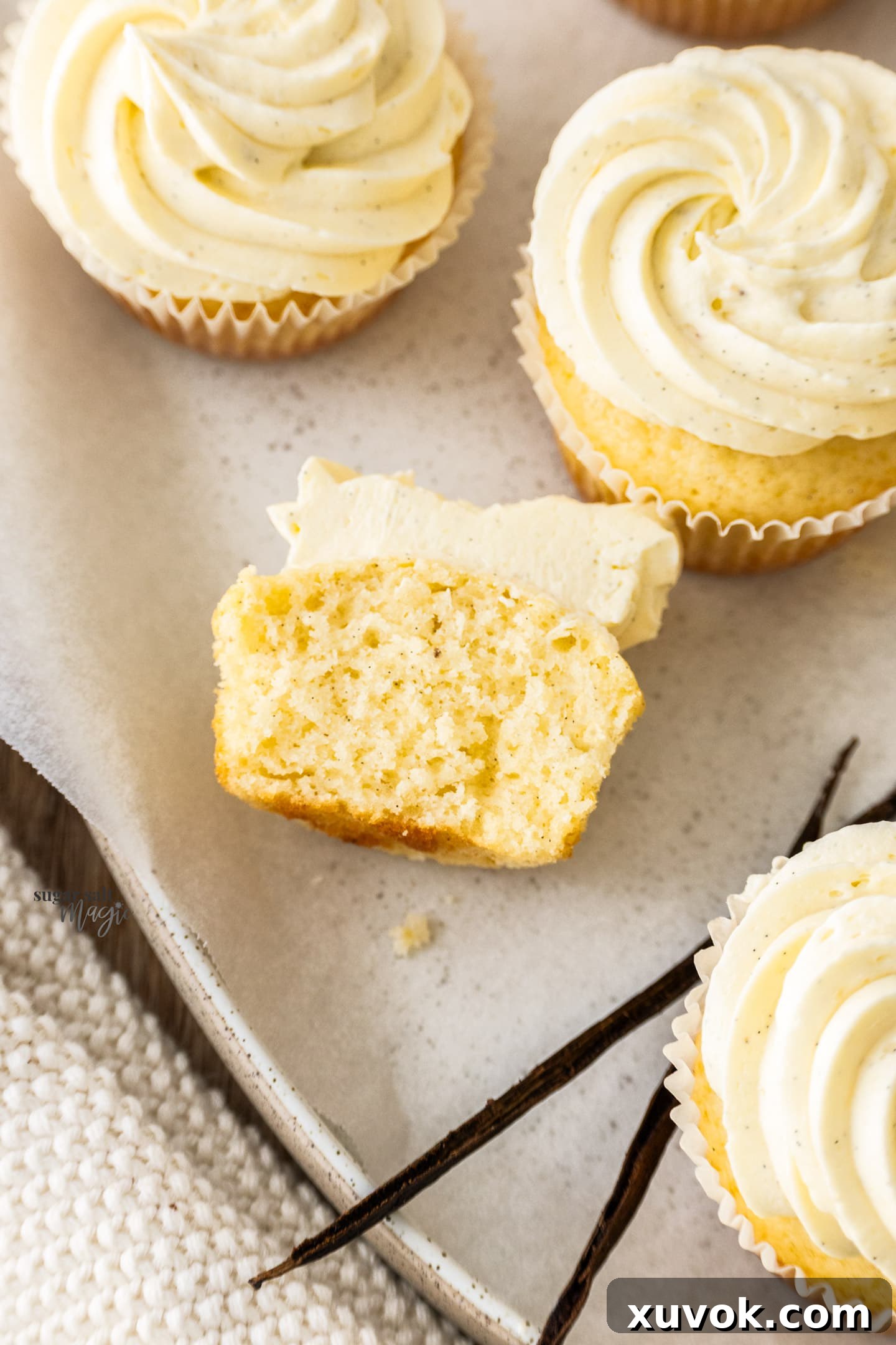 A vanilla cupcake cut open to show its perfectly moist and tender interior.