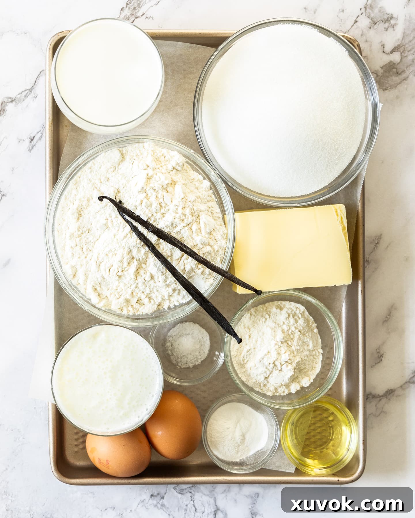 Ingredients for vanilla bean cupcakes laid out on a surface.