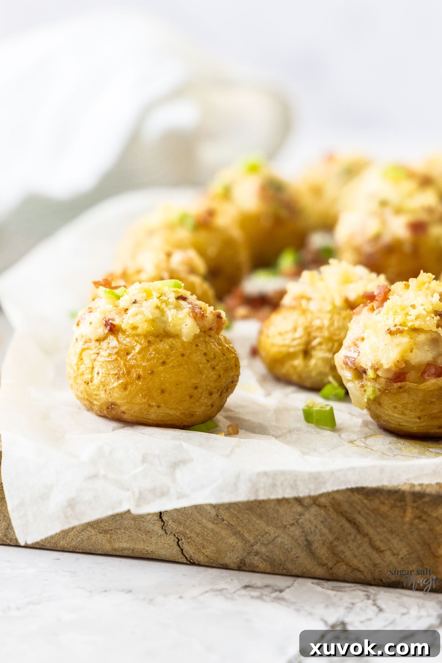 An assortment of baked mini potatoes arranged on a rustic wooden board, ready for serving.