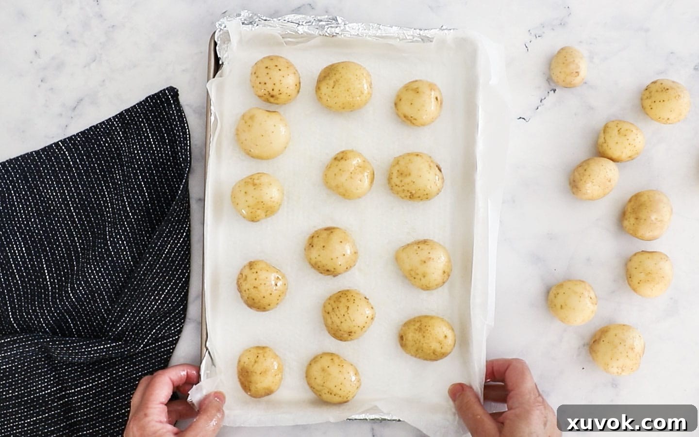 Baby potatoes on a baking tray, lightly oiled and salted, ready for roasting.