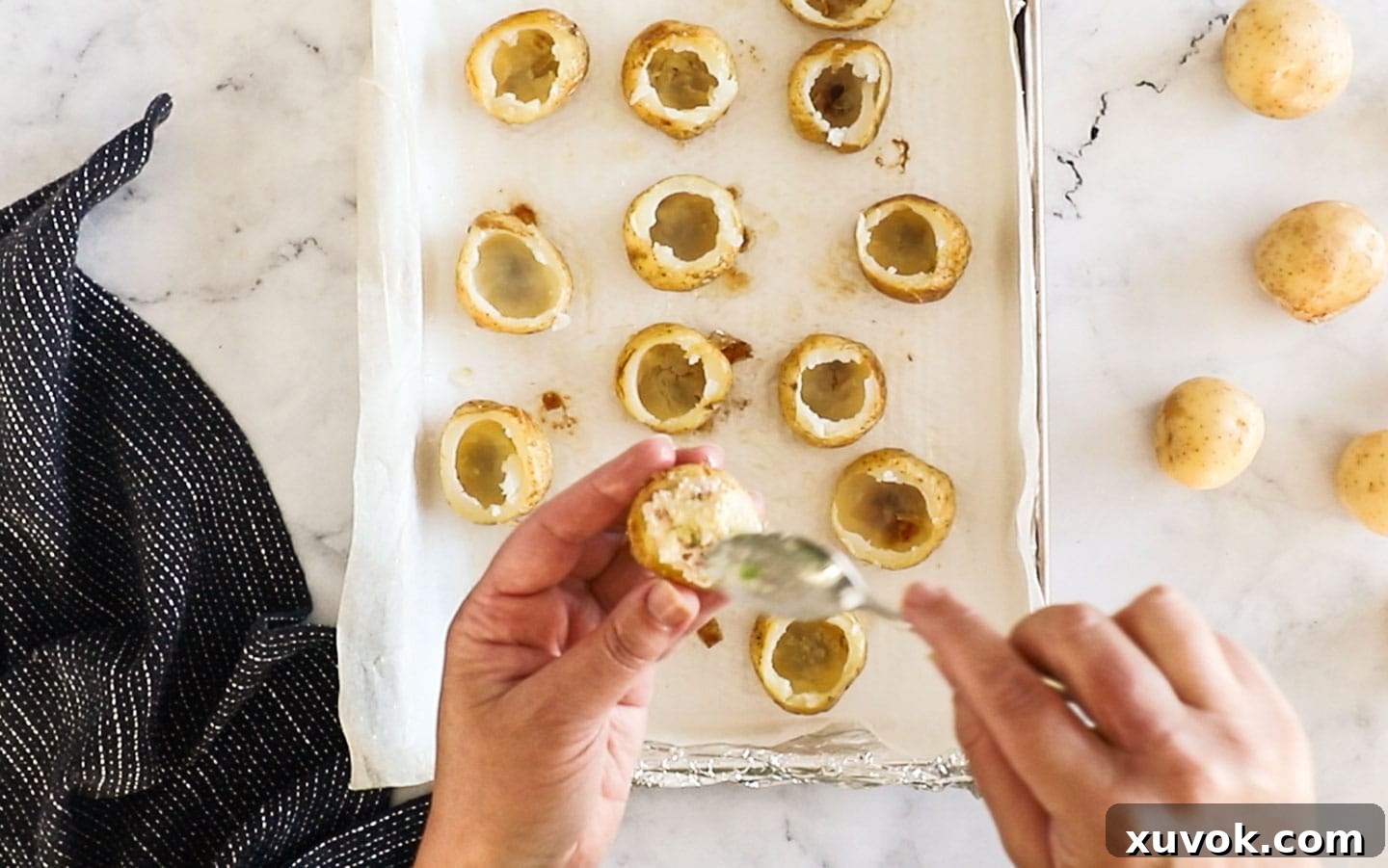 The hollowed potato skins being filled generously with the creamy potato mixture.