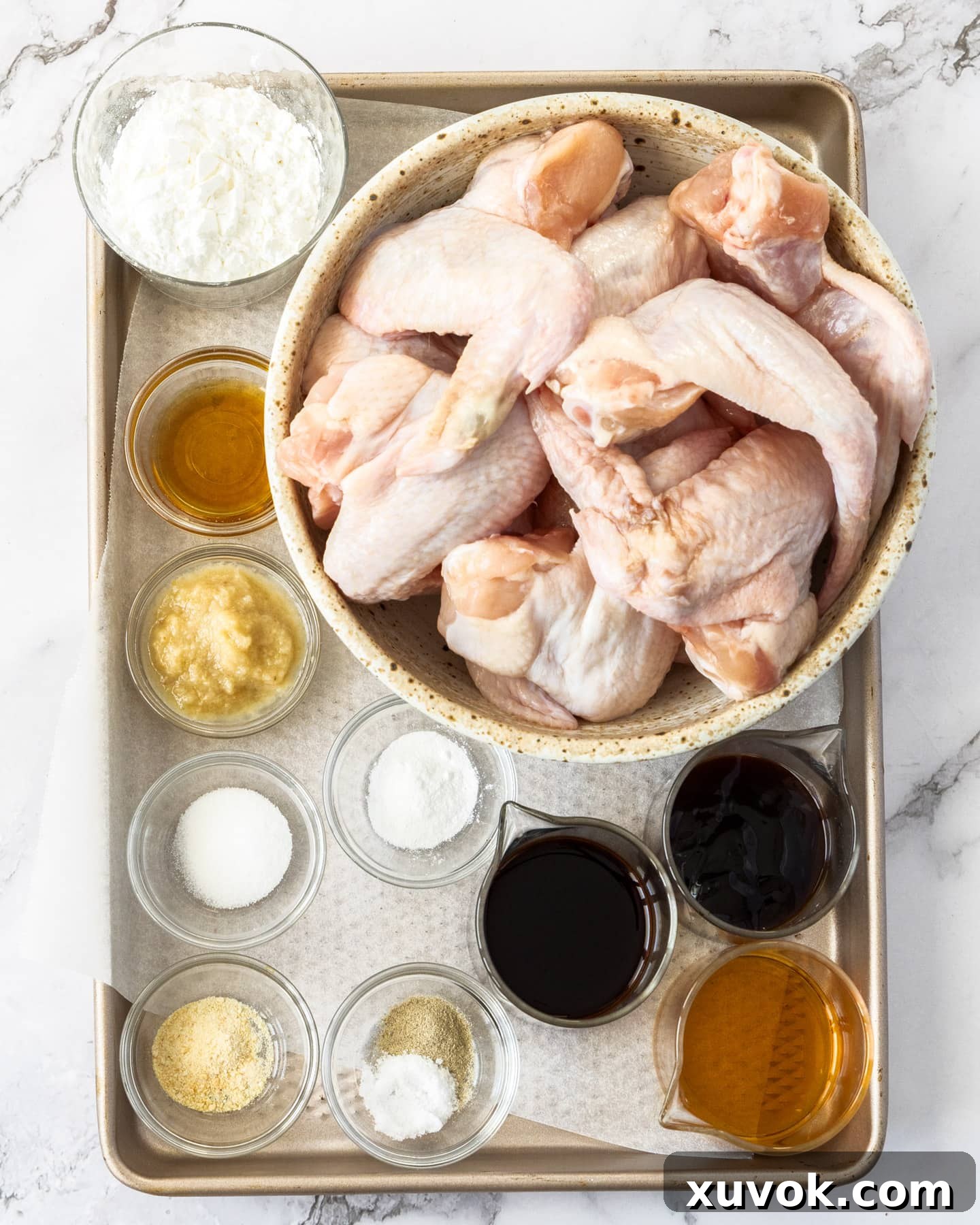 A selection of fresh ingredients laid out, including chicken wings, spices, and sauces, ready for making Chinese fried chicken wings.