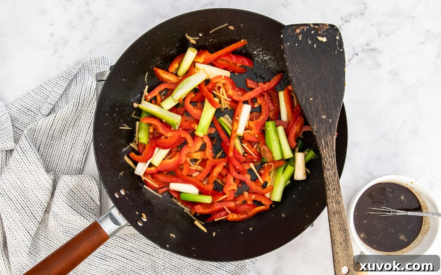 Colorful vegetables, ginger, and garlic stir-frying in a wok.
