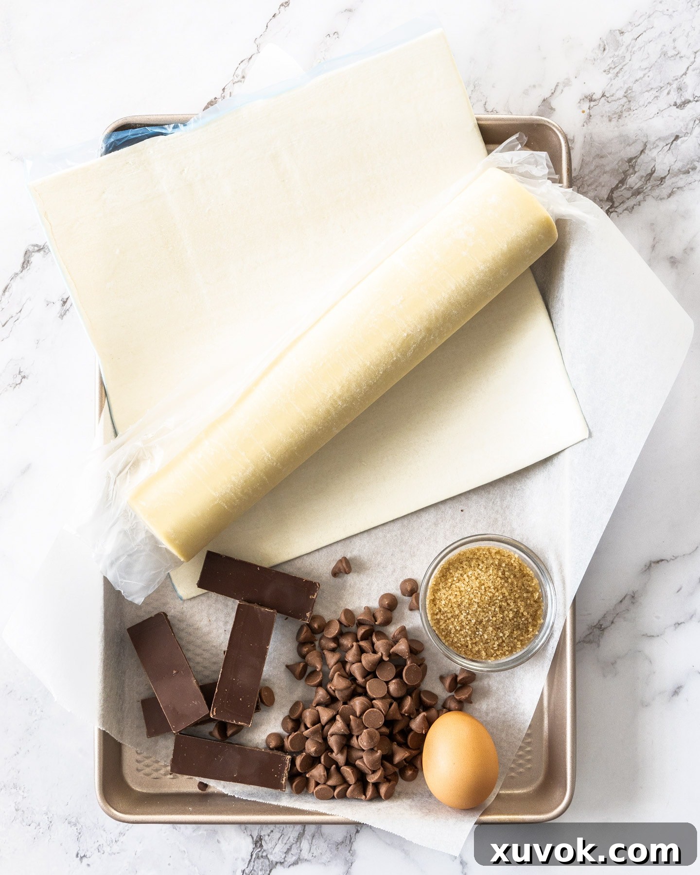 Ingredients for chocolate puff pastries on a baking tray.